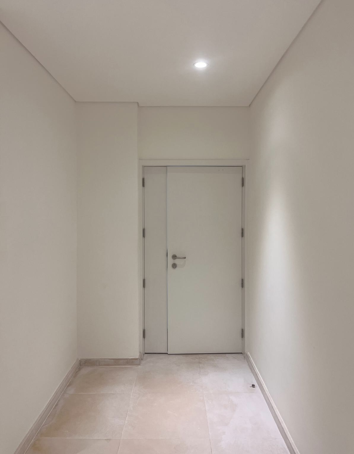 Corredor branco com porta ao fundo